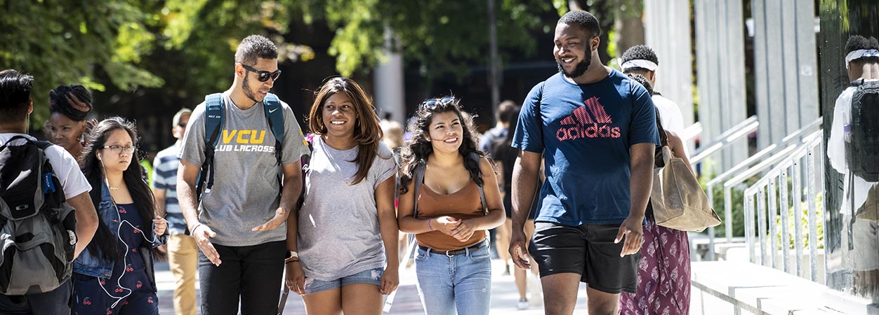 Students walk down the sidewalk on the Monroe Park Campus of VCU.