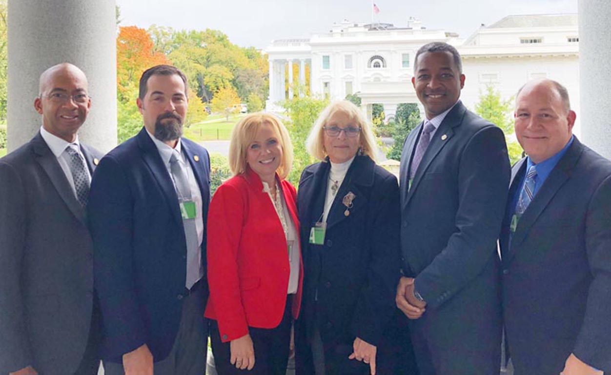 The complete group from Virginia (from left): Dr. Van Wilson and Todd Estes from the Virginia Community College System, Dr. Tina Manglicmot from the Virginia Department of Education, Dr. Sue Magliaro of Virginia Tech, and Dr. Al Byers. The White House is in background.