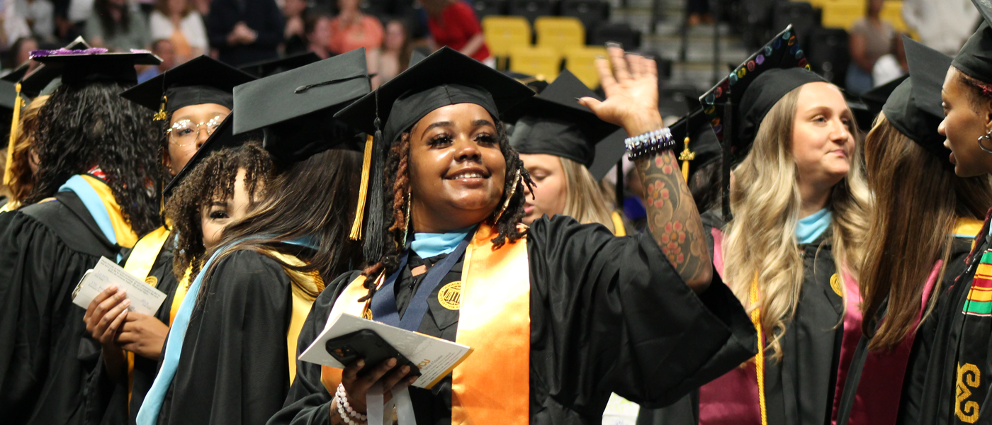 Graduating student waving to crowd