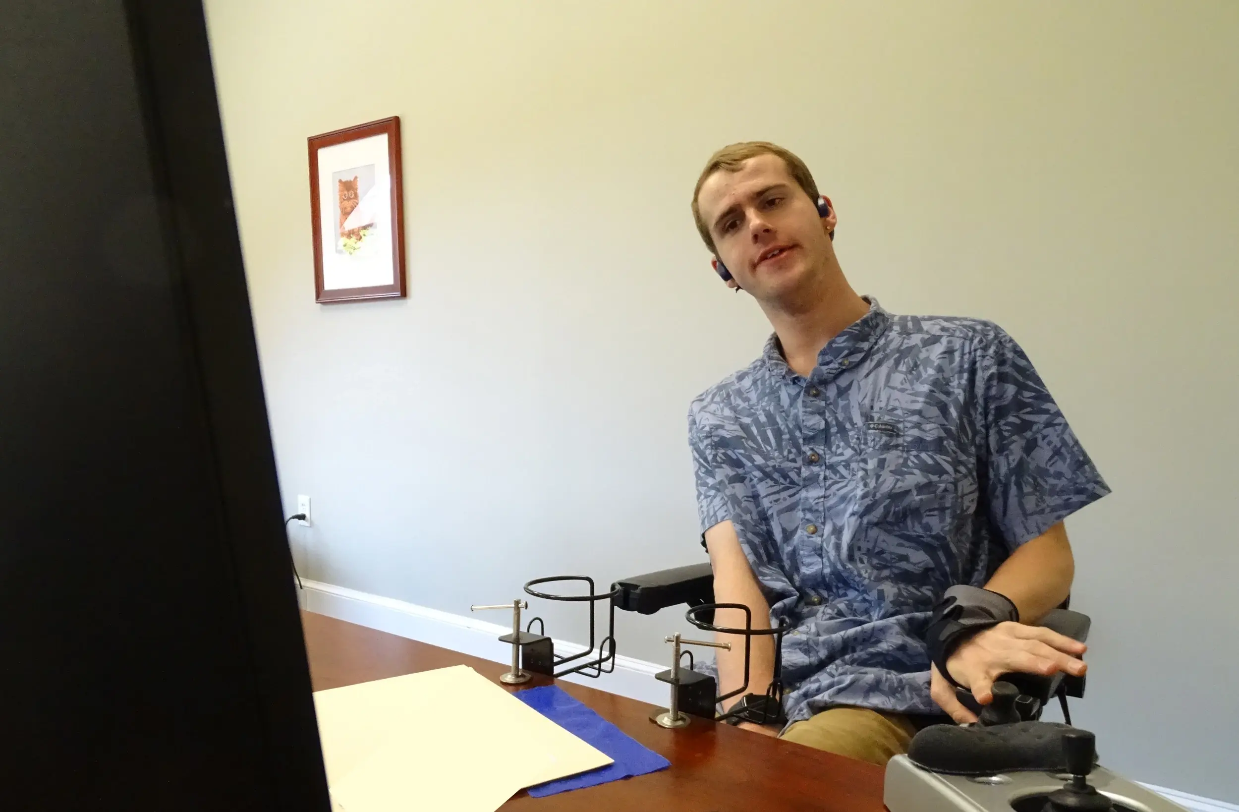 Lowery uses a dwell clicker, an assistive technology device, to help him complete his work duties. (Photo by Lucian Friel)
